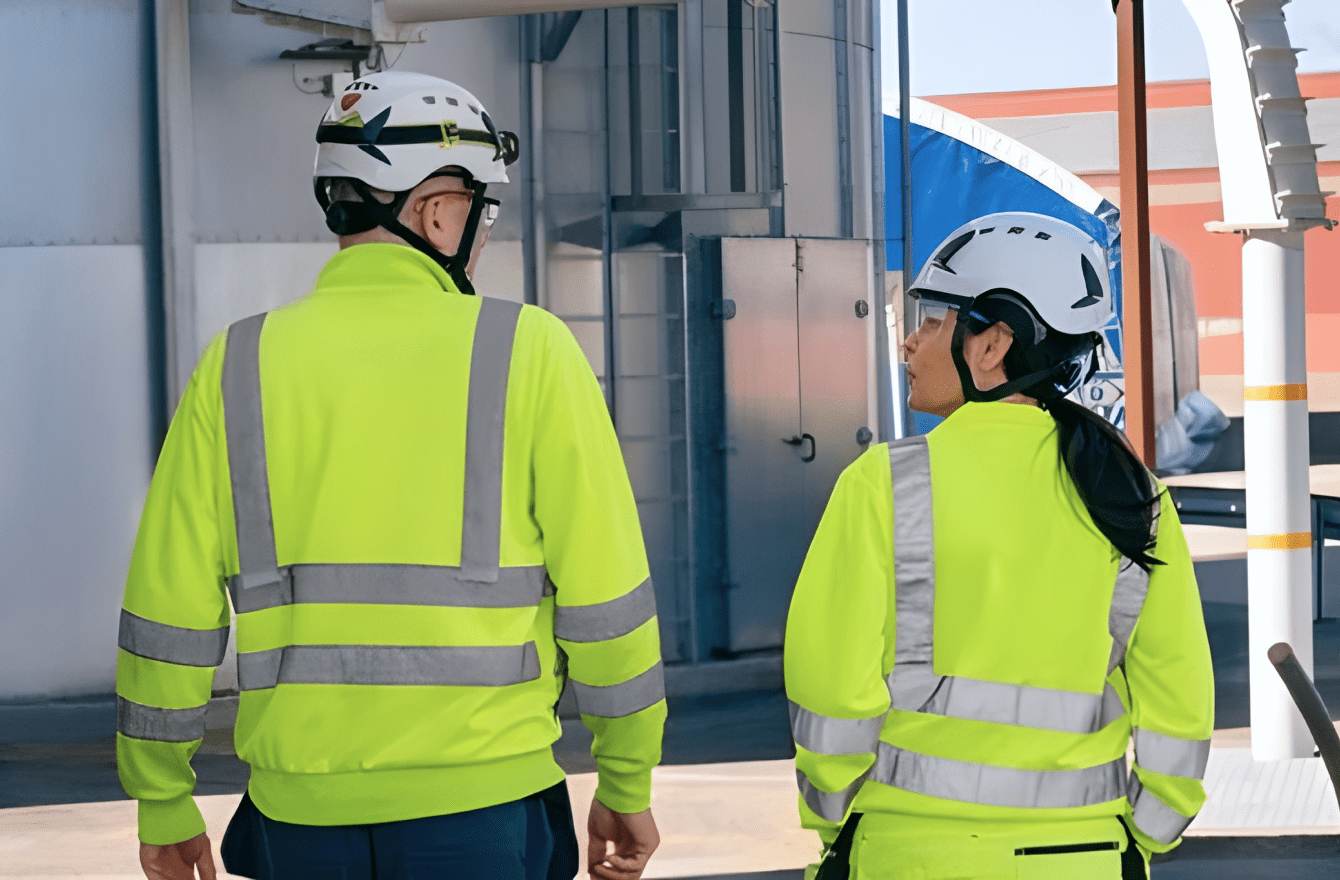 Two Stora Enso employees in high-vis gear walking through an industrial site, symbolizing operational consistency and teamwork.